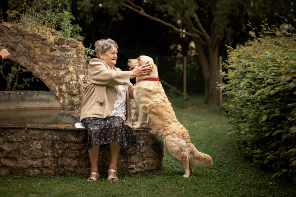 médiation animale, Une femme est assise auprès d'un chien golden retriever, tenant sa tête dans ses mains. Les deux sont les yeux dans les yeux.
